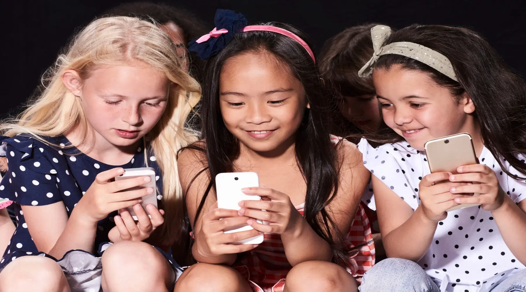 Young kids with phones_GettyImages_1800x1000